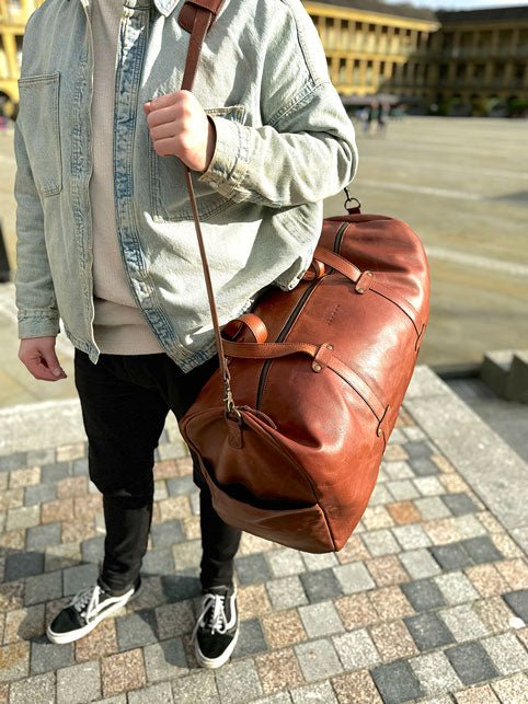 Lifestyle carry demonstration illustrating the proportions of the Large Leather Duffel Bag